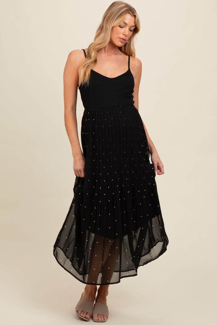 woman wearing a black maternity dress with spaghetti straps and a pleated skirt adorned with small sequins