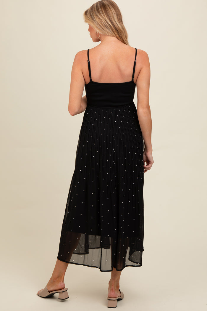 woman wearing a black maternity maxi dress with spaghetti straps and pleated skirt detailing, shown from the back