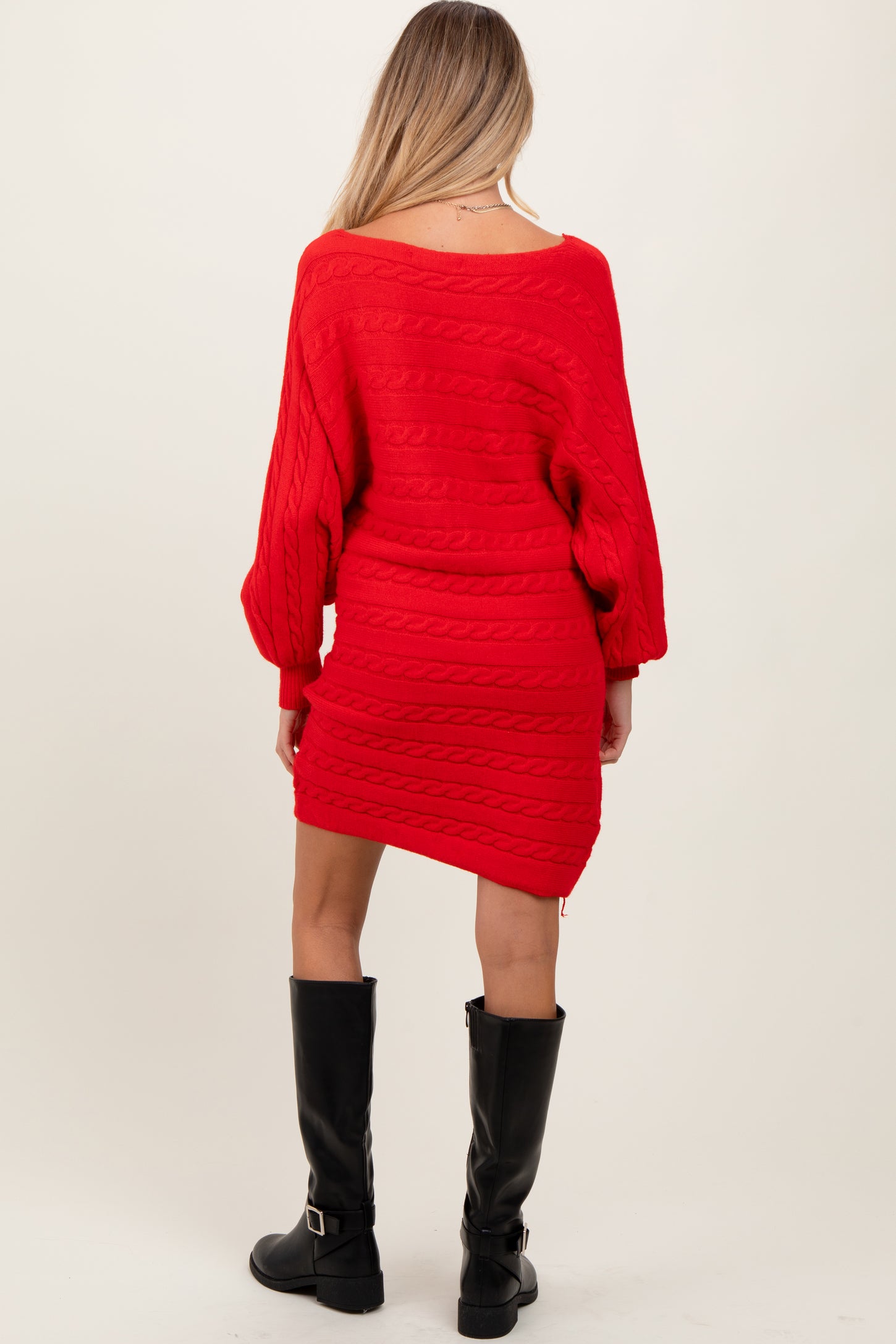 woman wearing a bright red cable knit maternity dress with long sleeves and a fitted silhouette