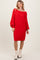 woman wearing a red cable knit sweater dress with long sleeves and a loose fit, styled with ankle boots