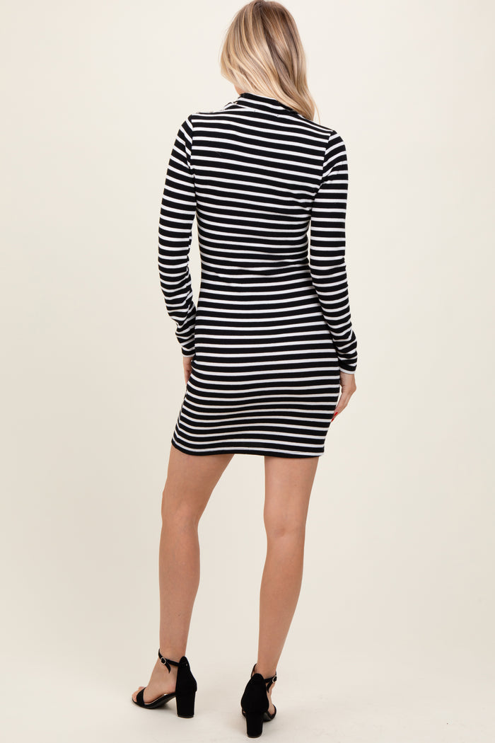 woman wearing a black and white striped long sleeve dress, view from the back, paired with black heeled sandals