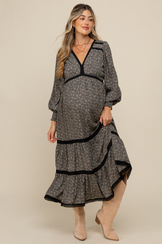woman wearing a floral print maternity dress with long sleeves and ruffle hem, showcasing her baby bump
