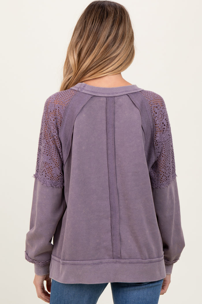 woman wearing a lavender maternity sweatshirt with detailed lace sleeves and a relaxed fit, view from the back