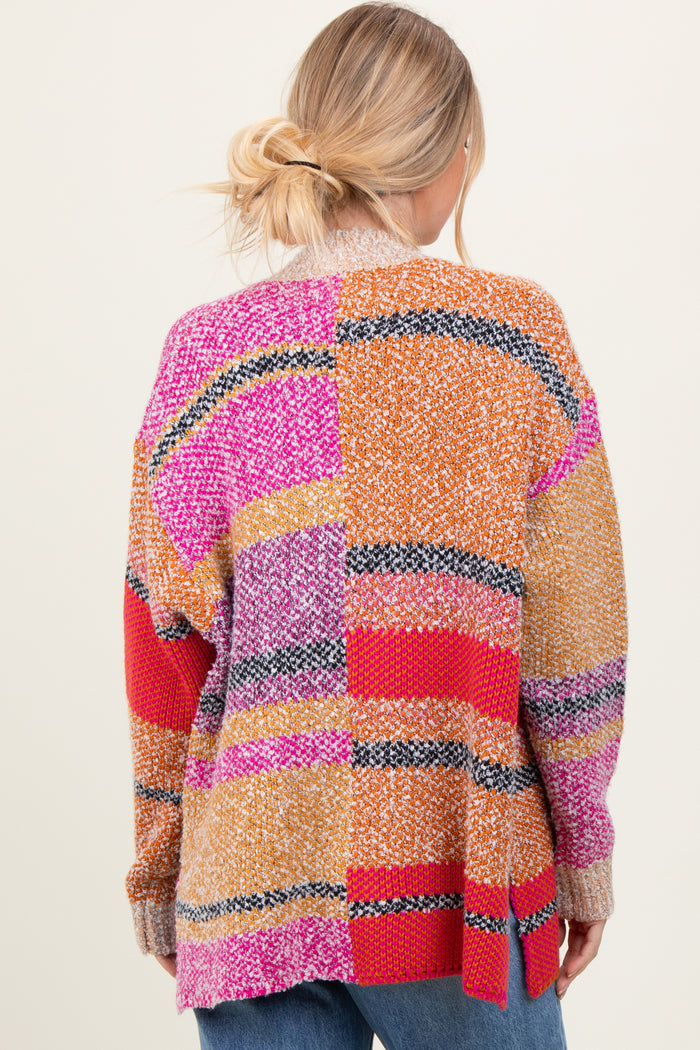 woman wearing a multicolored oversized sweater with a patchwork design and a cozy knit texture