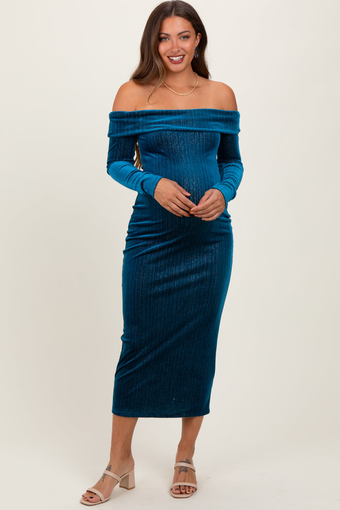 woman wearing a teal off-the-shoulder maternity dress that highlights her baby bump