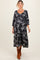 woman wearing a black floral print maternity dress with puff sleeves and a visible baby bump
