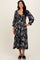 woman wearing a black and white floral midi dress with puffed sleeves and a tiered skirt