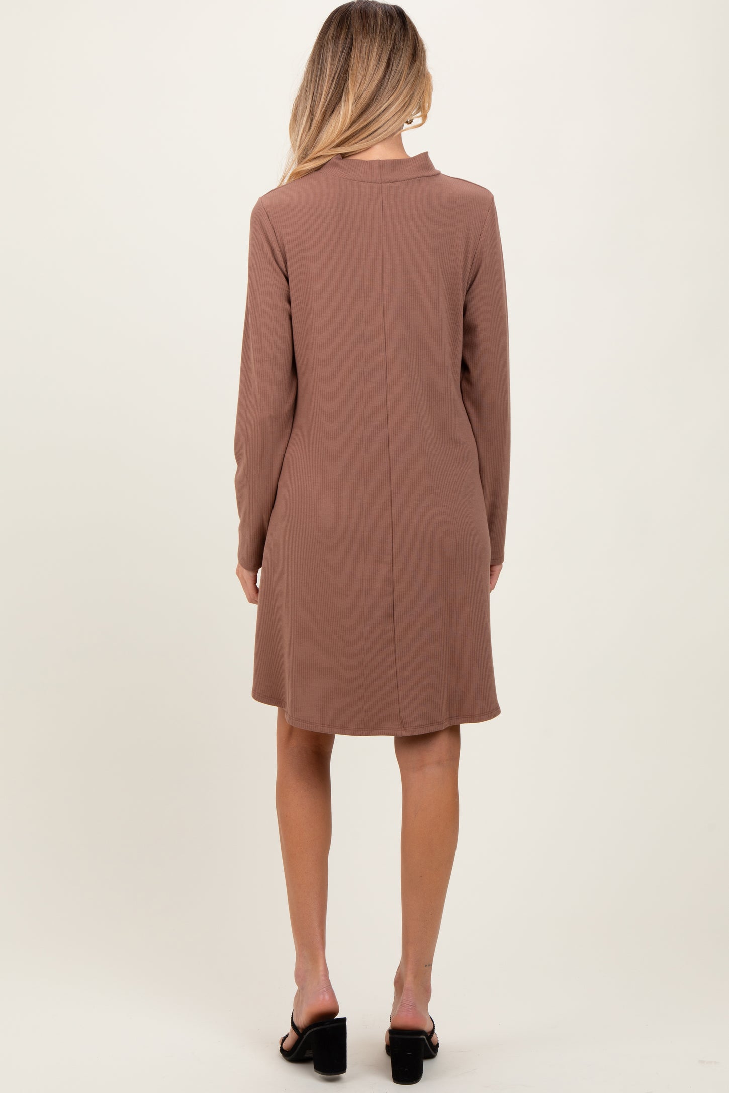 woman wearing a brown long sleeve maternity dress, shown from the back, with a relaxed fit and above-the-knee length