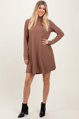woman wearing a brown long sleeve ribbed mini dress and black ankle boots