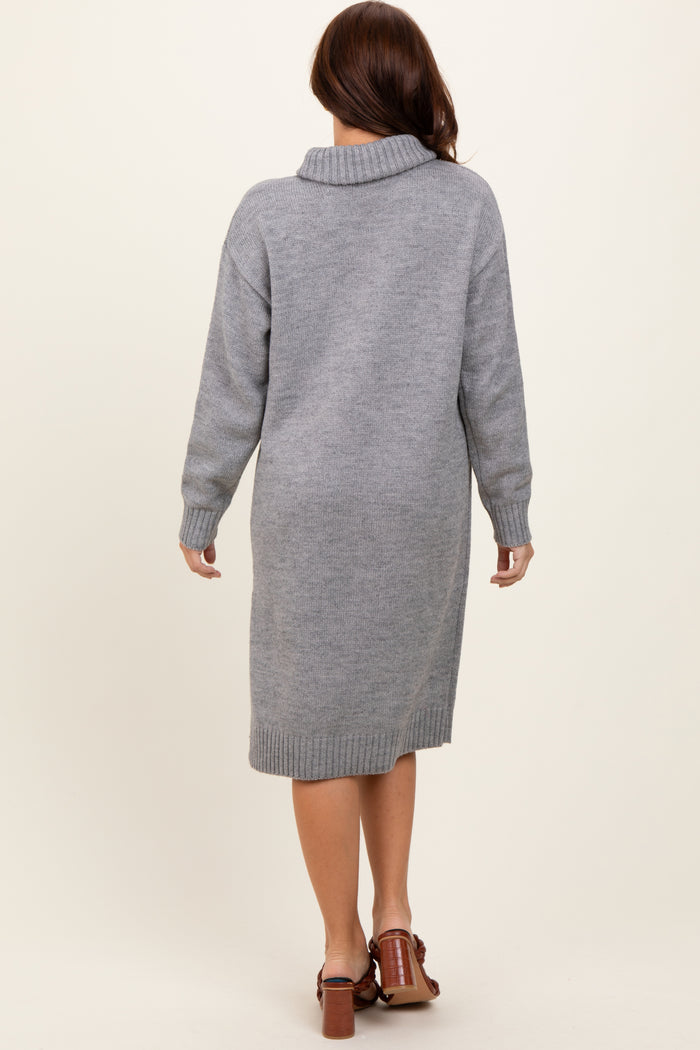 woman wearing a gray knit sweater dress with a high collar and long sleeves, viewed from the back