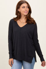 woman wearing a dark gray v-neck sweater with a relaxed fit and side slits, styled with light blue jeans