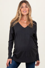 woman wearing a dark gray maternity sweater with a v-neck and a visible baby bump