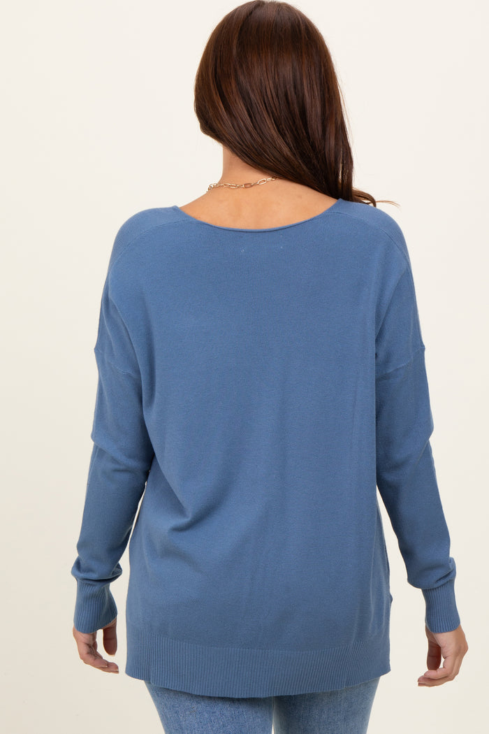 woman wearing a cozy blue back-view sweater with long sleeves and a relaxed fit