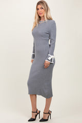 woman wearing a gray ribbed knit midi dress with white ribbon details on the sleeves and black high-heeled shoes