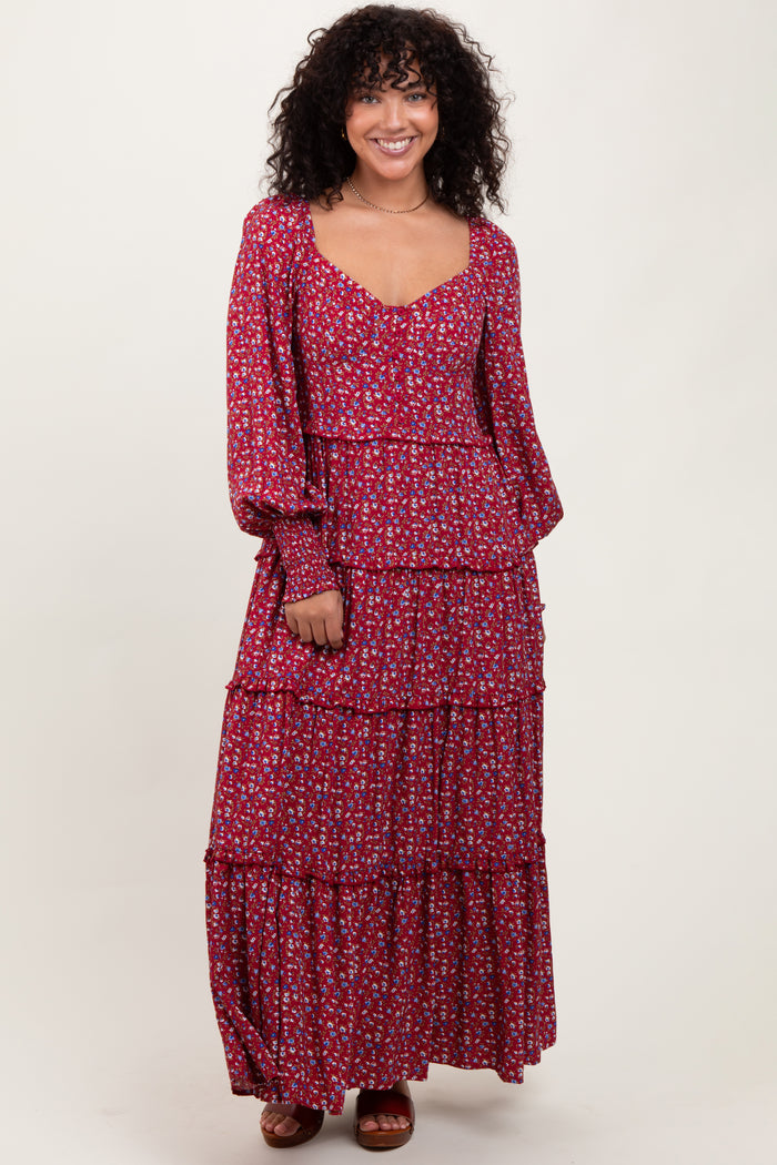 woman wearing a red floral tiered maxi dress with long sleeves and a scooped neckline