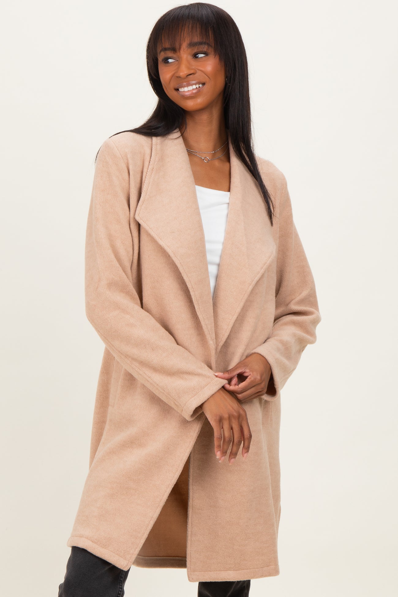 woman wearing a beige long cardigan with an open front and relaxed fit