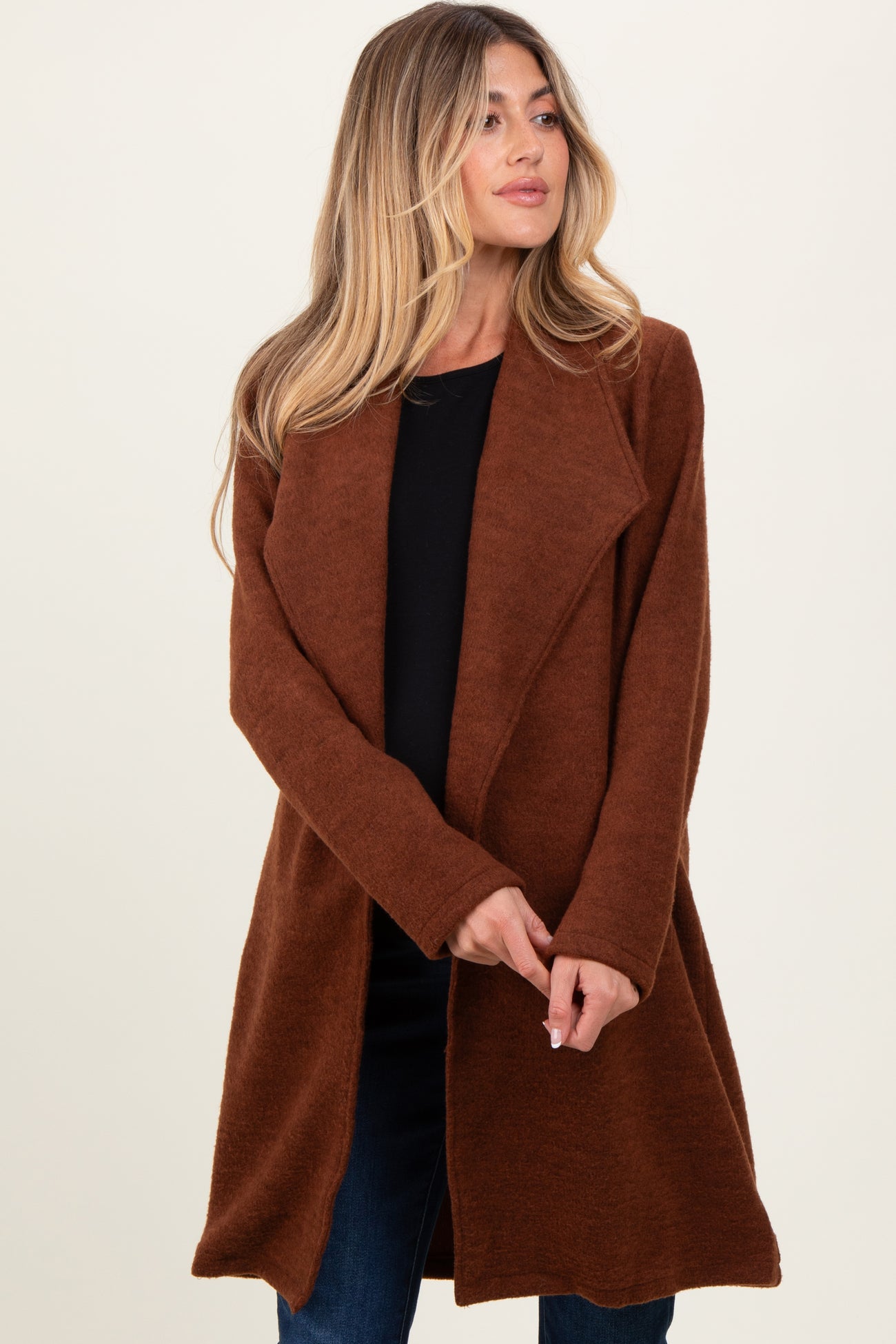 woman wearing a rust-colored maternity cardigan with an open front and long sleeves