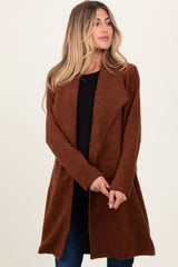 woman wearing a rust-colored maternity cardigan with an open front and long sleeves