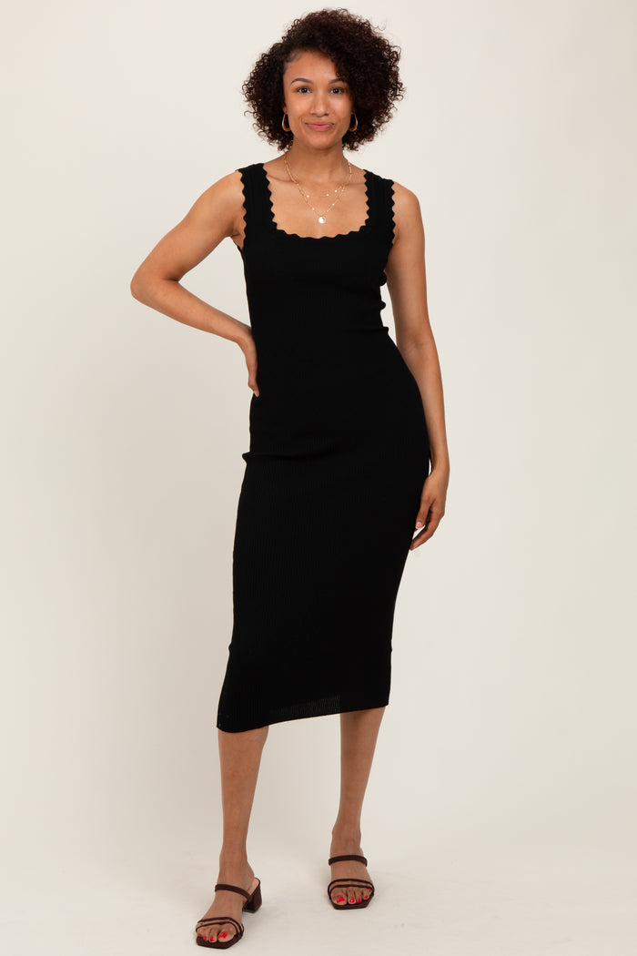 woman wearing a black ribbed midi dress with scalloped neckline and fitted silhouette