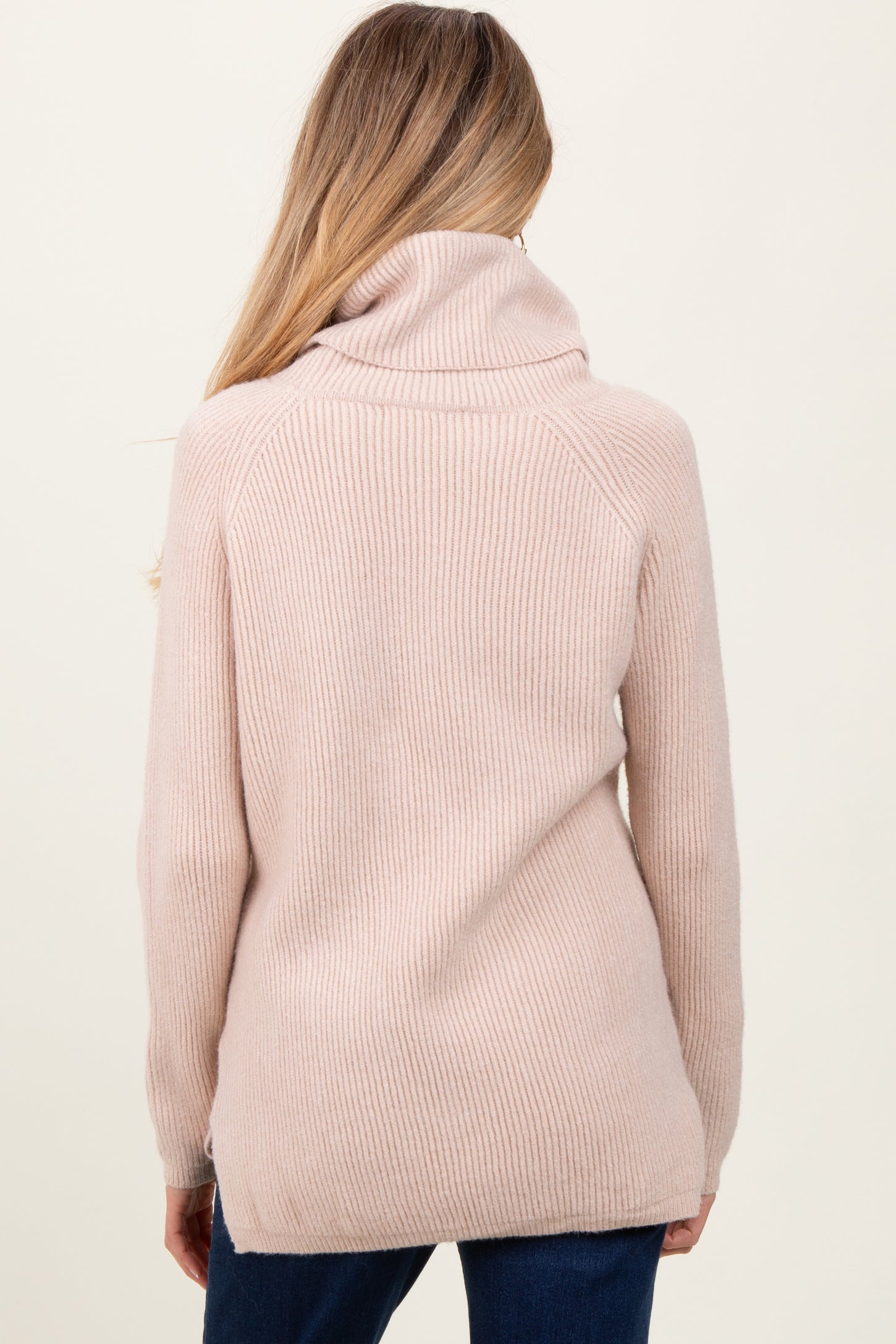 woman wearing a soft pink maternity sweater with a cowl neck and ribbed texture, view from the back