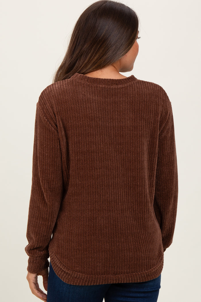 woman wearing a brown ribbed maternity sweater seen from the back