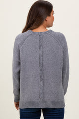 woman wearing a gray maternity sweater with a textured back detail, styled with long sleeves and a relaxed fit