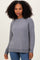 woman wearing a grey knit sweater with a ribbed hem and side slits, paired with blue jeans