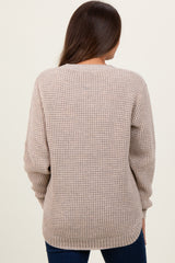 woman wearing a light beige knit maternity sweater from the back with long sleeves and a relaxed fit