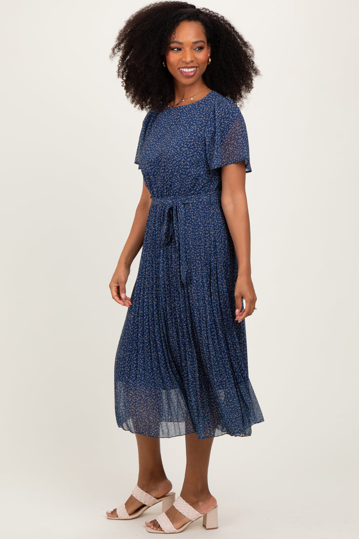 woman wearing a navy blue floral midi dress with short sleeves and a tie waist detail