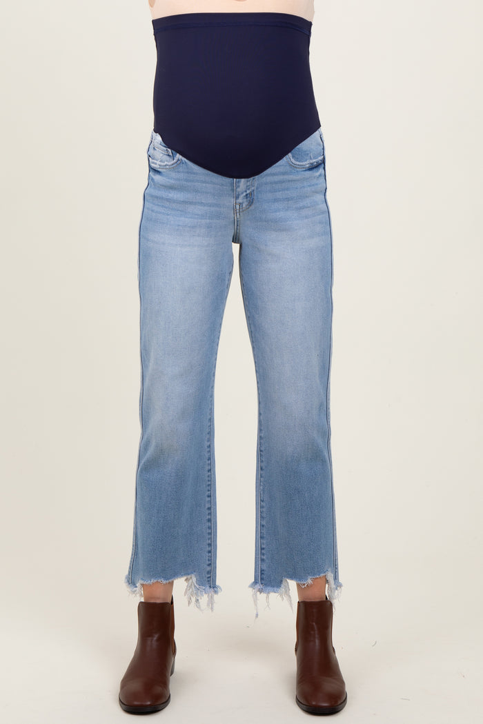 woman wearing light wash maternity jeans with a frayed hem and a navy stretchy maternity panel