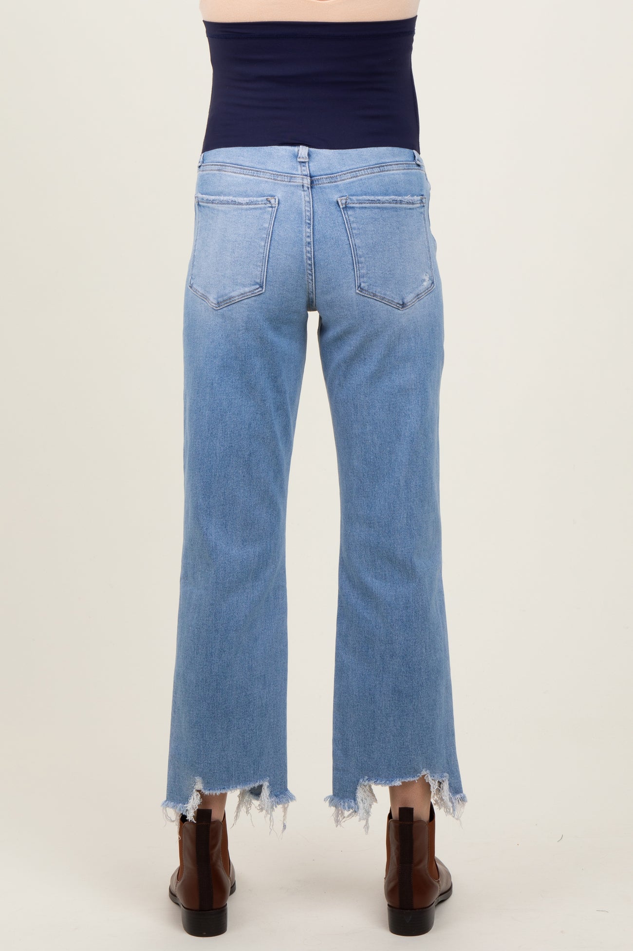 woman wearing maternity light blue cropped jeans with frayed hems, viewed from the back