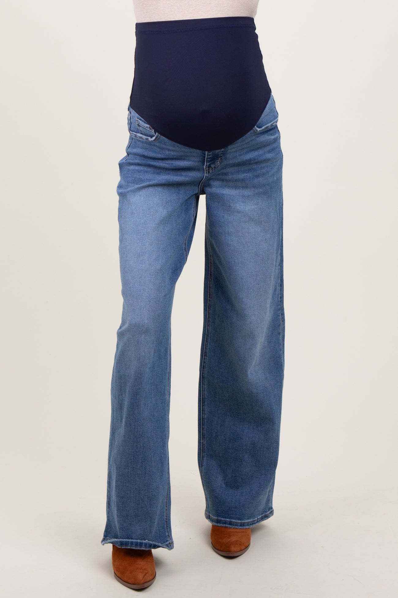 woman wearing a pair of blue maternity jeans with a navy blue over-the-bump waistband and wide-leg fit