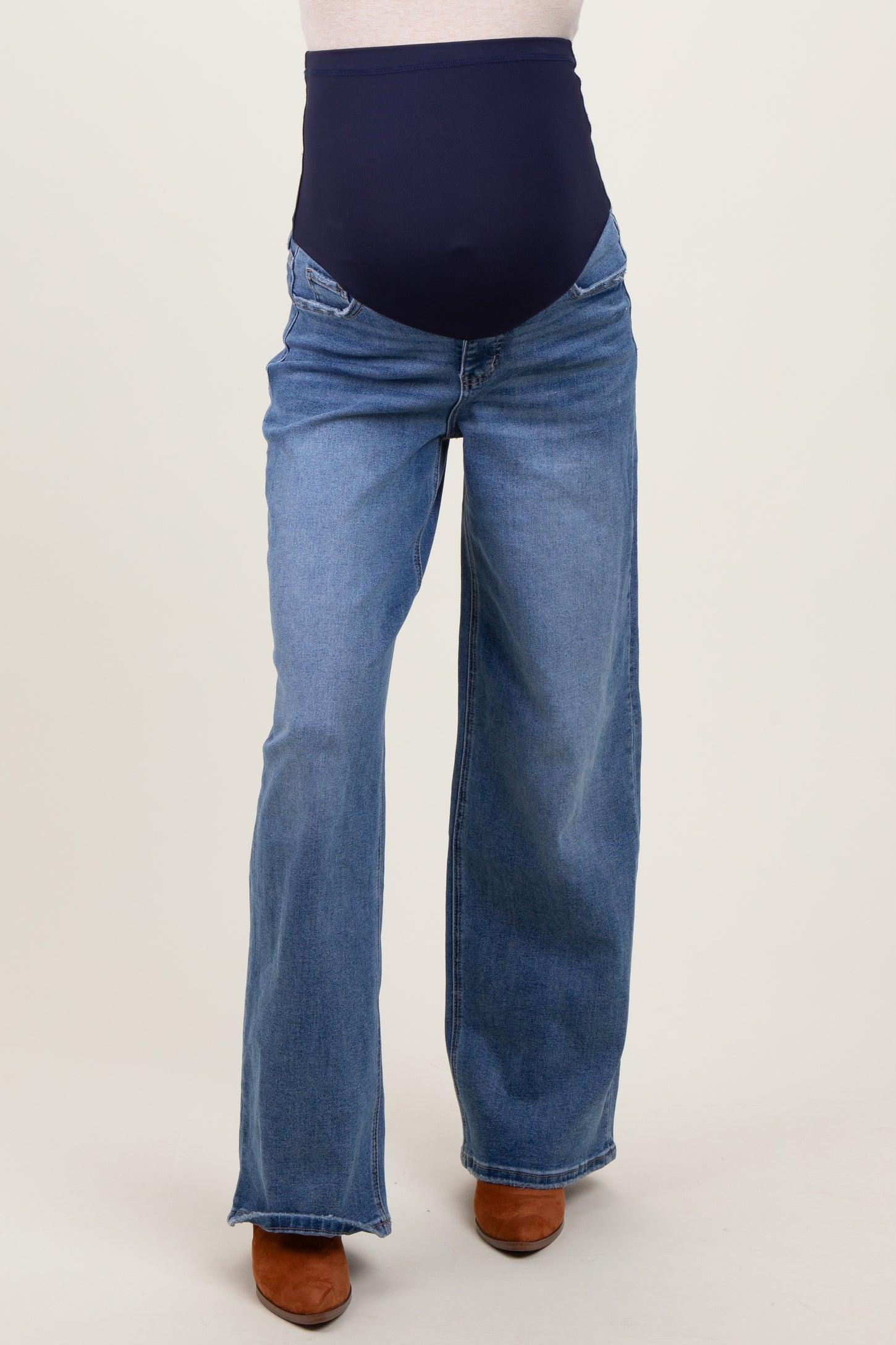 woman wearing a pair of blue maternity jeans with a navy blue over-the-bump waistband and wide-leg fit