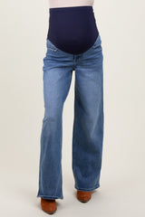woman wearing a pair of blue maternity jeans with a navy blue over-the-bump waistband and wide-leg fit