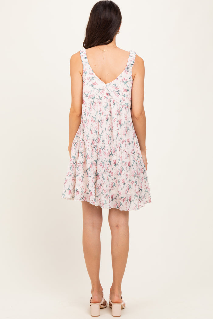 woman wearing a floral patterned sleeveless sundress with ruffled straps and a flared skirt
