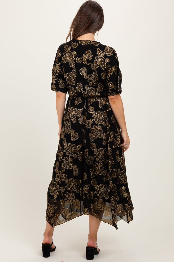 woman wearing a black floral maternity dress with gold details, featuring short sleeves and a high-low hemline