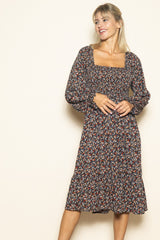 woman wearing a black floral print midi dress with puff sleeves and a square neckline