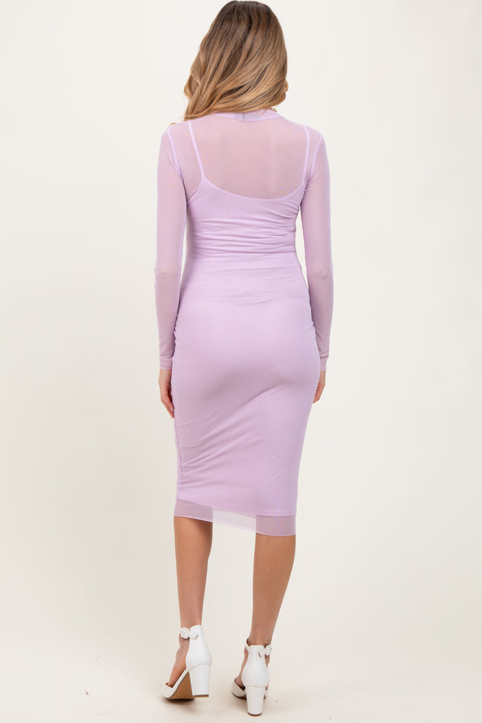 woman wearing a light purple long sleeve maternity dress with a fitted silhouette and sheer back details