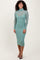 woman wearing a mint green long sleeve sheer dress with a fitted silhouette and a turtleneck collar.