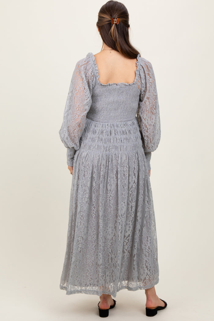 woman wearing a light grey lace maternity dress with puff sleeves and a smocked bodice, shown from the back