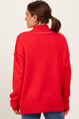 woman wearing a bright red oversized pullover sweater with a high collar and relaxed fit, viewed from the back