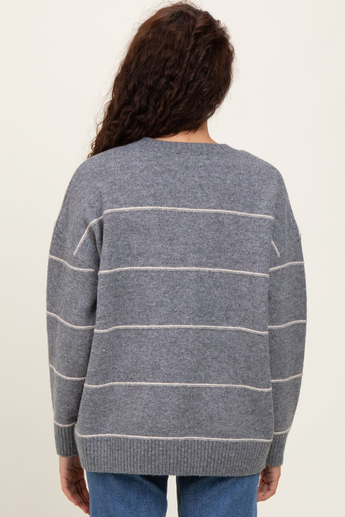 woman wearing a gray striped oversized sweater with a soft knit texture, viewed from the back
