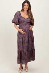 woman wearing a purple floral maternity maxi dress with puff sleeves and a baby bump visible