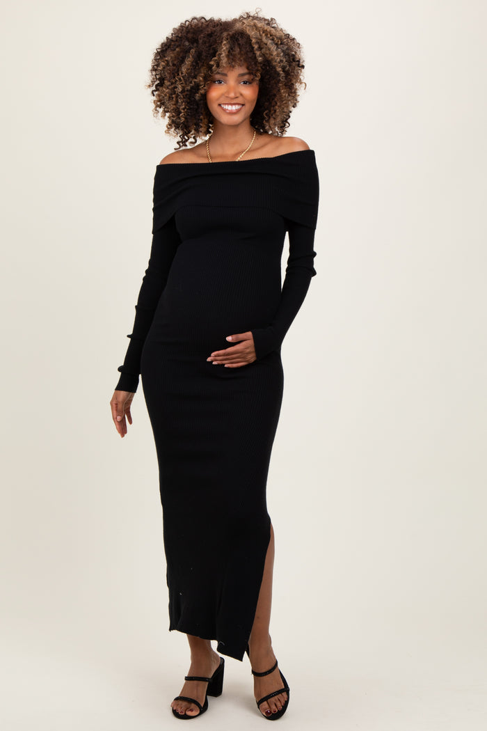 woman wearing a black off-the-shoulder ribbed maternity dress with a side slit and holding her baby bump