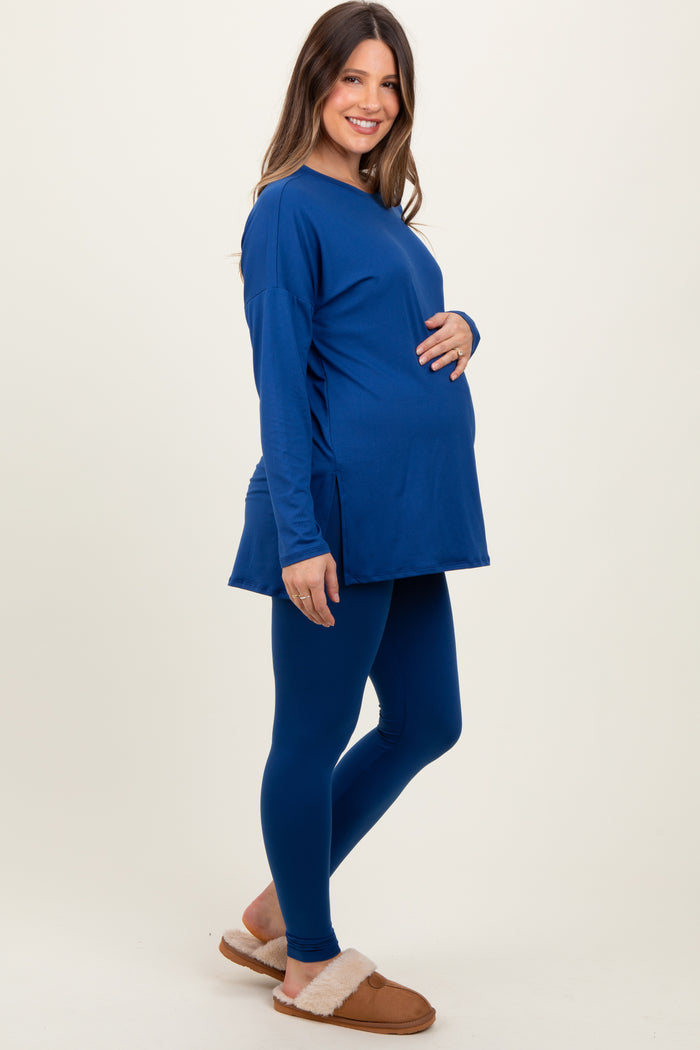 woman wearing a navy blue long sleeve maternity top and matching leggings, showing her baby bump