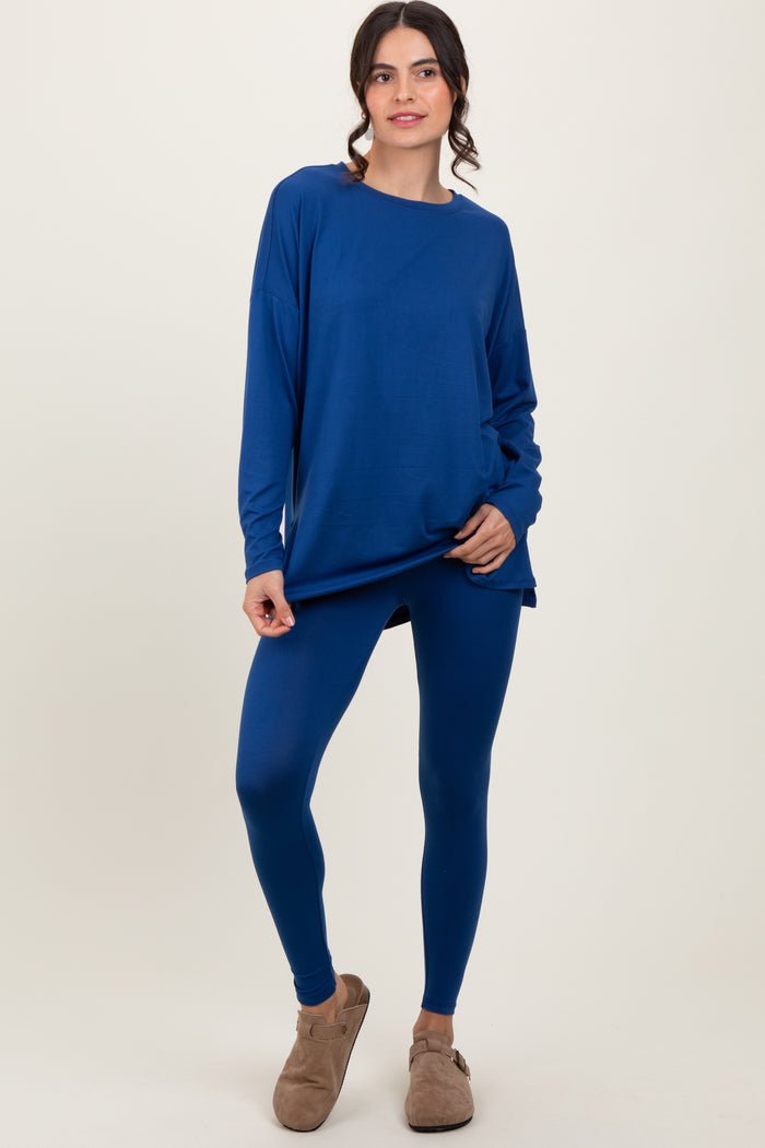 woman wearing a deep blue long sleeve top and matching leggings, paired with cozy slippers