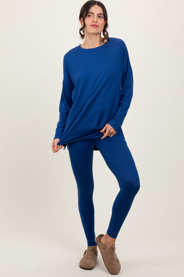 woman wearing a blue long sleeve top and matching leggings, styled with cozy brown slip-on shoes