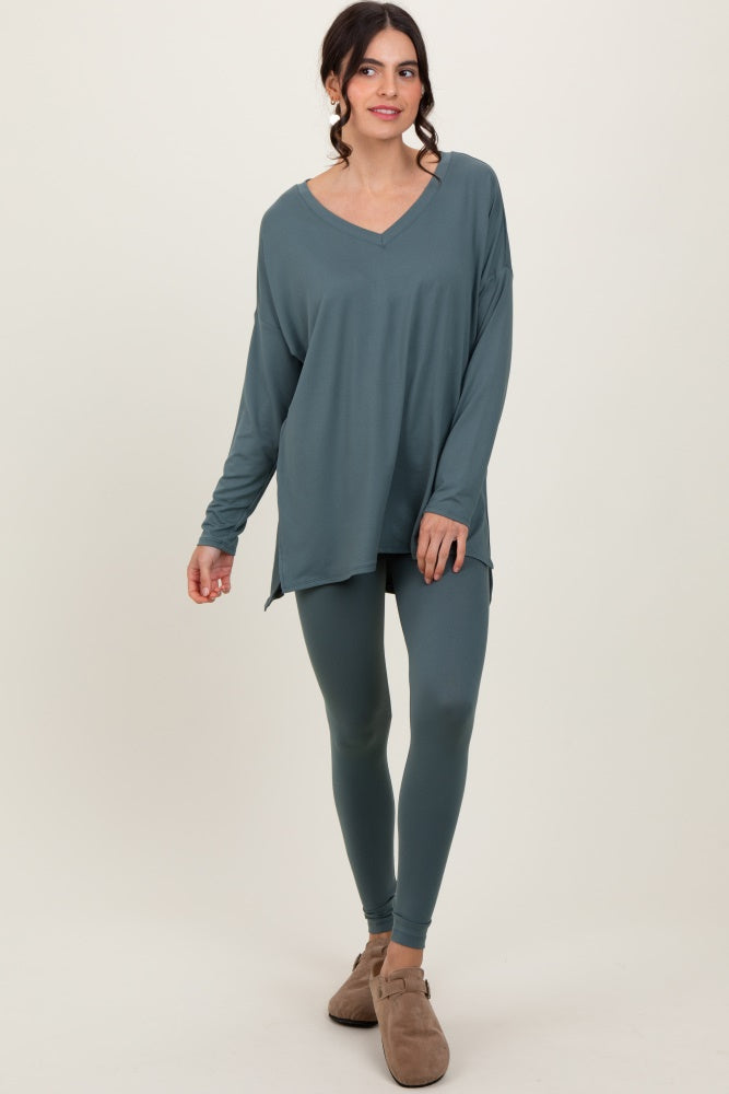 woman wearing a teal long sleeve v-neck top paired with matching leggings and casual shoes