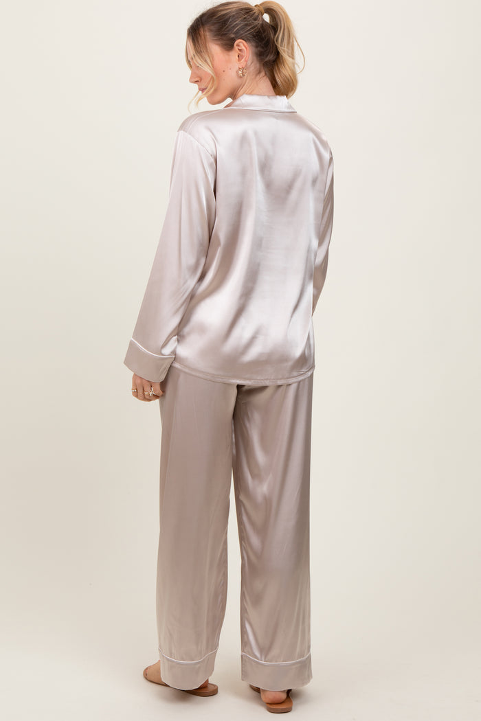 woman wearing a light beige satin pajama set with long sleeves and wide-leg pants, viewed from the back