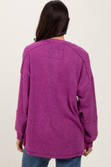 woman wearing a purple oversized corduroy sweater with dropped shoulders and long sleeves
